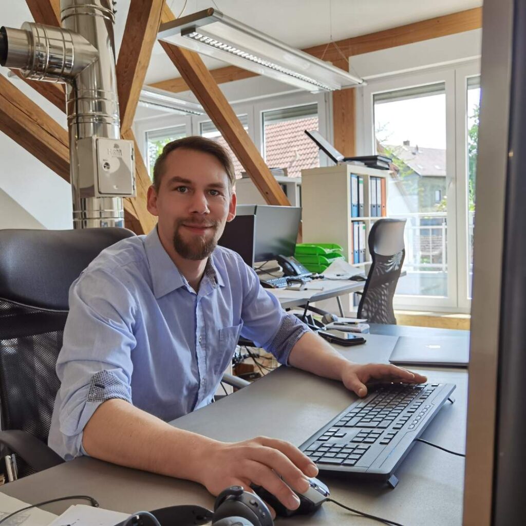 Mann sitzt am Schreibtisch im Büro: Donato Clausing